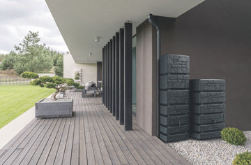 Zwei Regentonnen stehen auf einer Terrasse