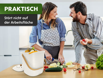 Zwei Personen sind in einer Küche mit der gemeinsamen Essenszubereitung beschäftigt. Im Mittelpunkt steht ein kompakter „YourCasa® Komposteimer“, der als praktisch und unaufdringlich am Arbeitsplatz hervorgehoben wird.