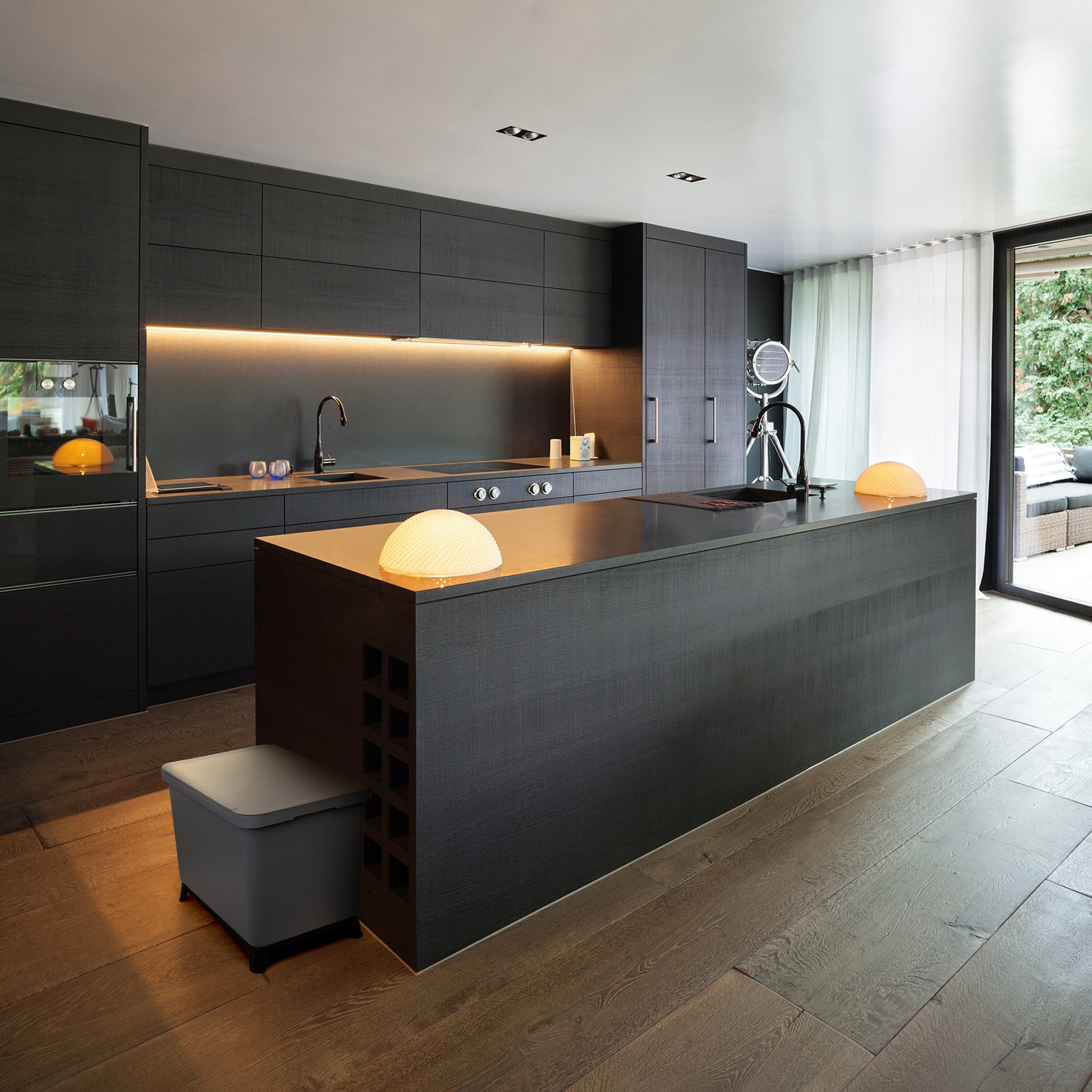 Eine moderne Küche mit einer schwarzen Insel und YourCasa® Mülleimer 2-4 Fächer [20-40L] im exklusiven Design – Mülltrennsystem mit Deckel und Fuß zur Mülltrennung.