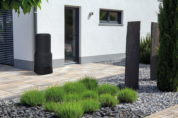 Modernes Hausäußeres mit gepflegter Gartenanlage und einer Regenwassersammeltonne mit YourCasa Regentonne [RainBell] mit Standfuß, Deckel und Wasserhahn von yourcasa-de.