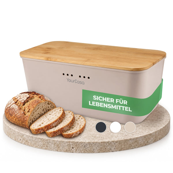 Brotkasten beige mit Bambusdeckel auf Natursteinplatte neben Brotscheiben